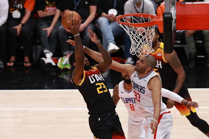 Royce O'Neale (23) scores over Nicolas Batum (33)